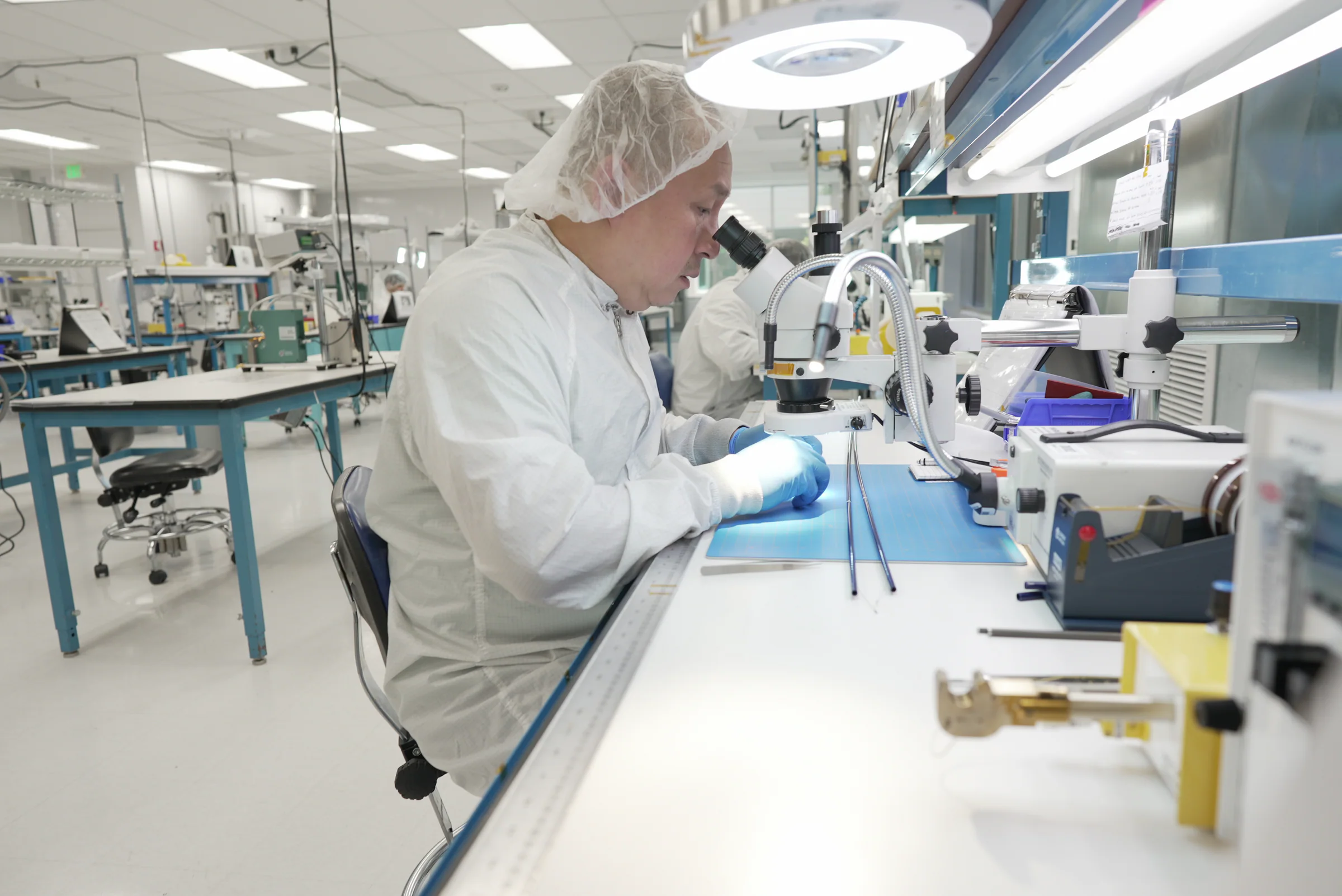 Cordica operator inspecting catheter components at a precision workstation