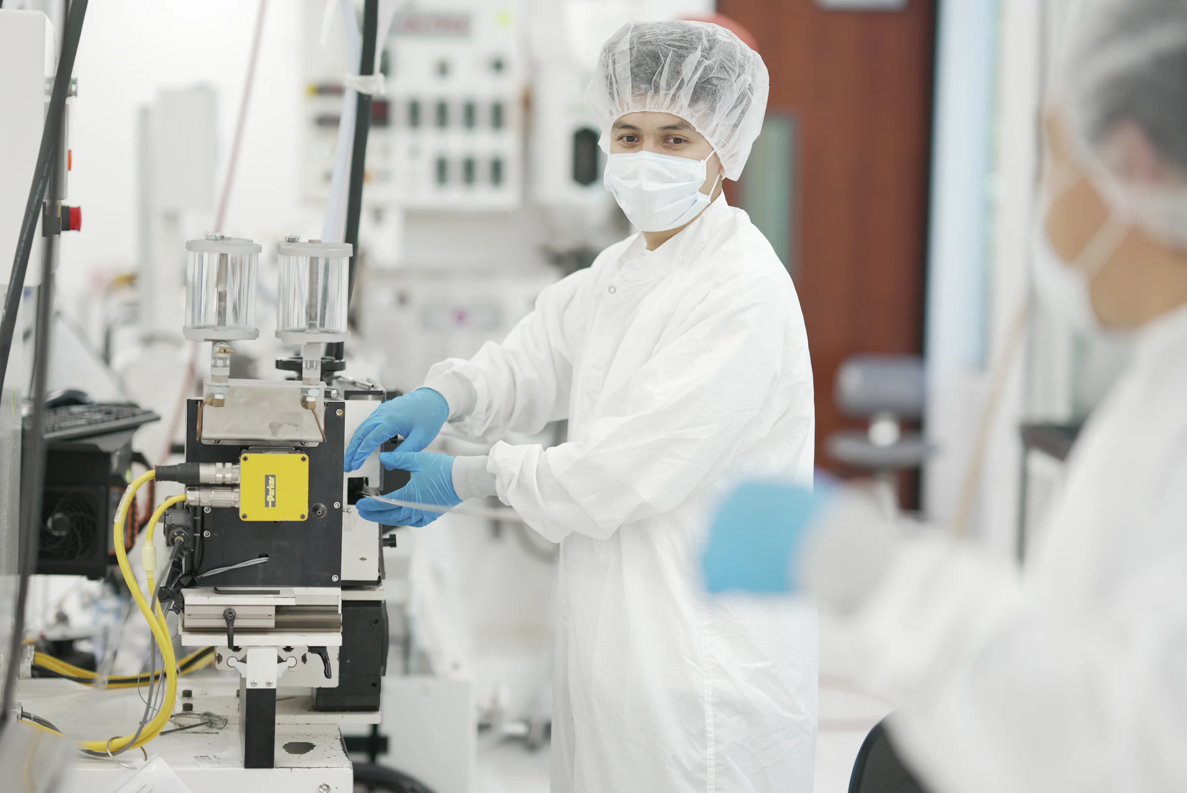 Cleanroom operator running medical tubing extrusion equipment