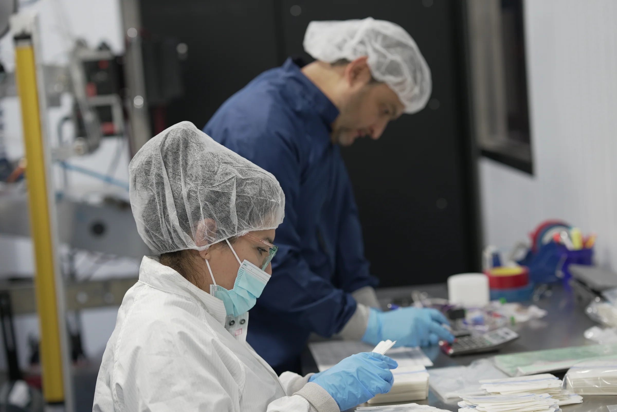 Team members examining medical components in a manufacturing workspace