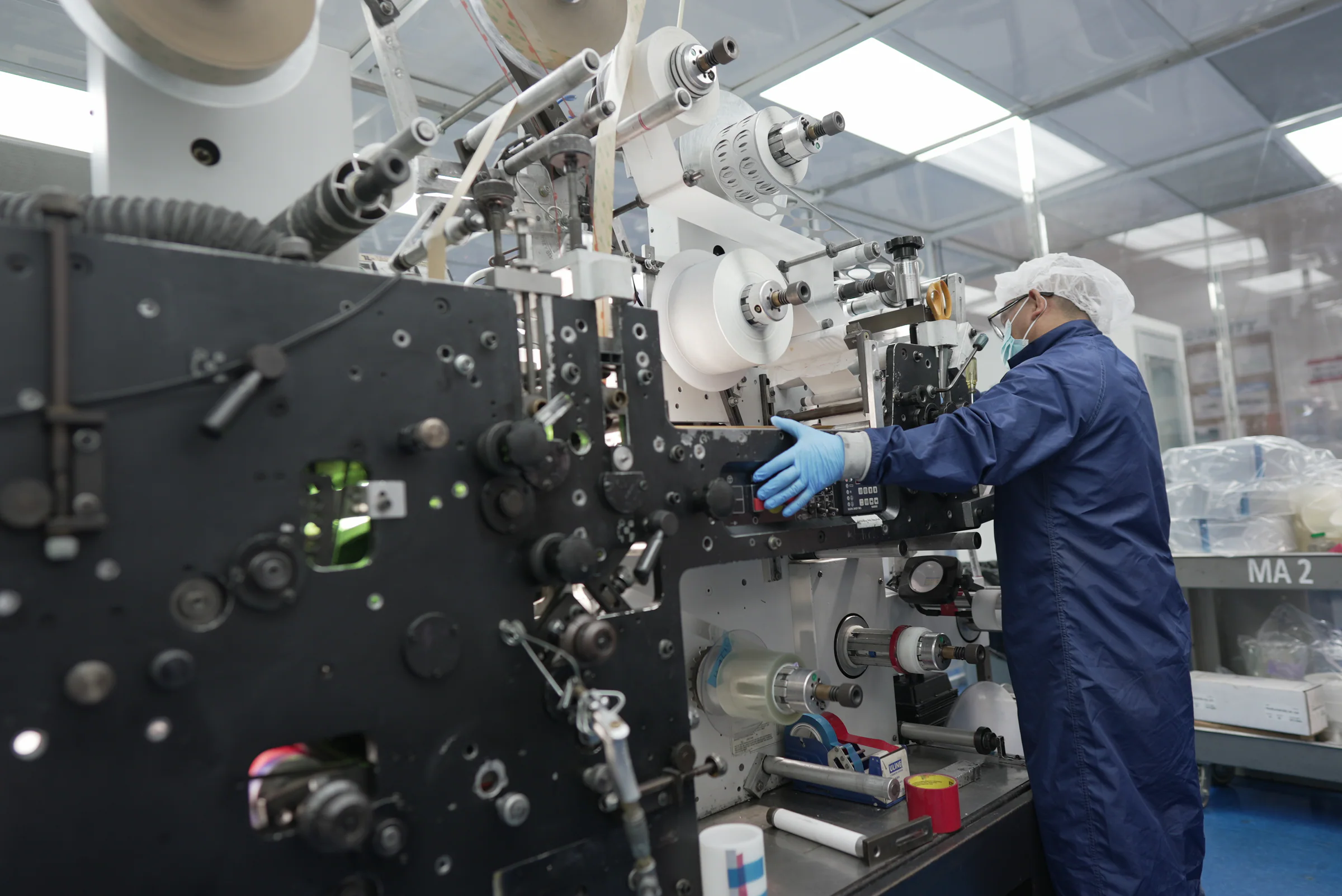 Medical converting operator working at production equipment