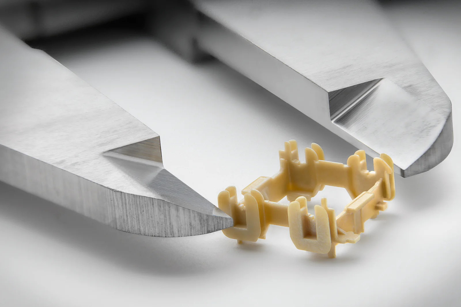 Micro-molded medical component held between precision inspection jaws