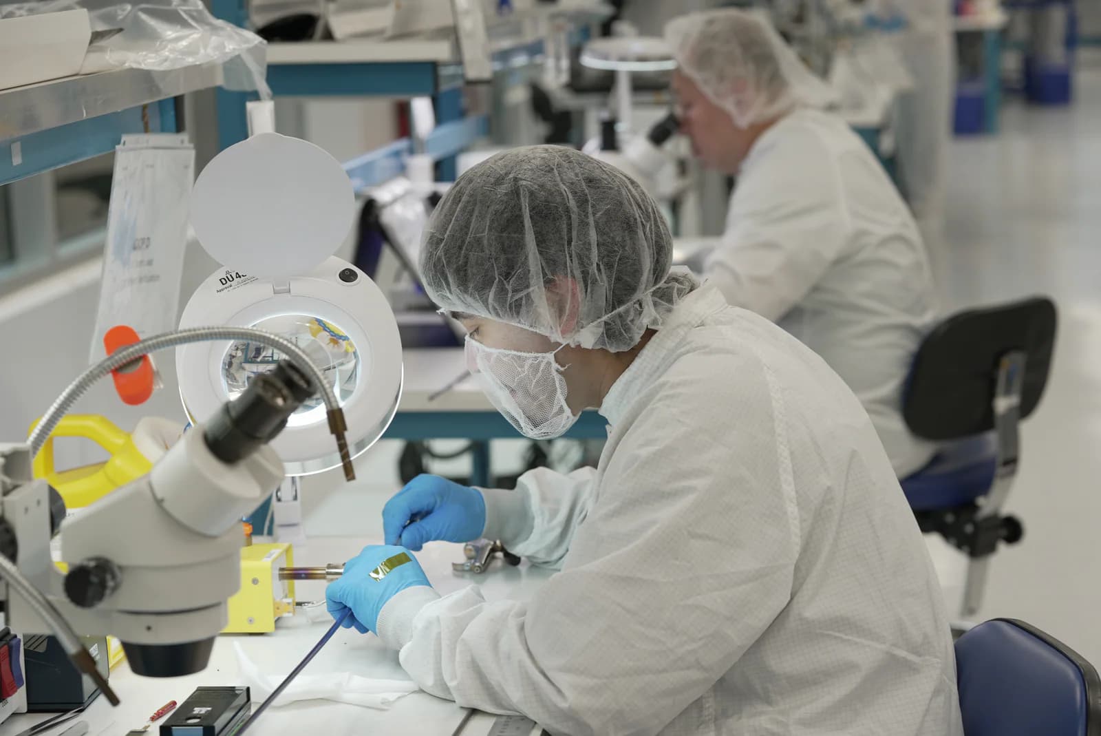 Cordica operator performing precision catheter component work at a manufacturing workstation