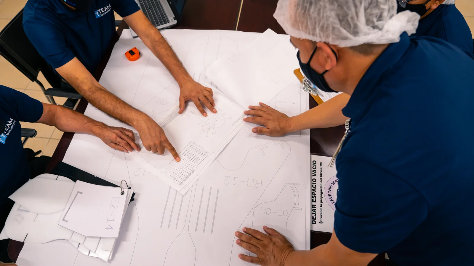 Cordica personnel collaborating over technical drawings