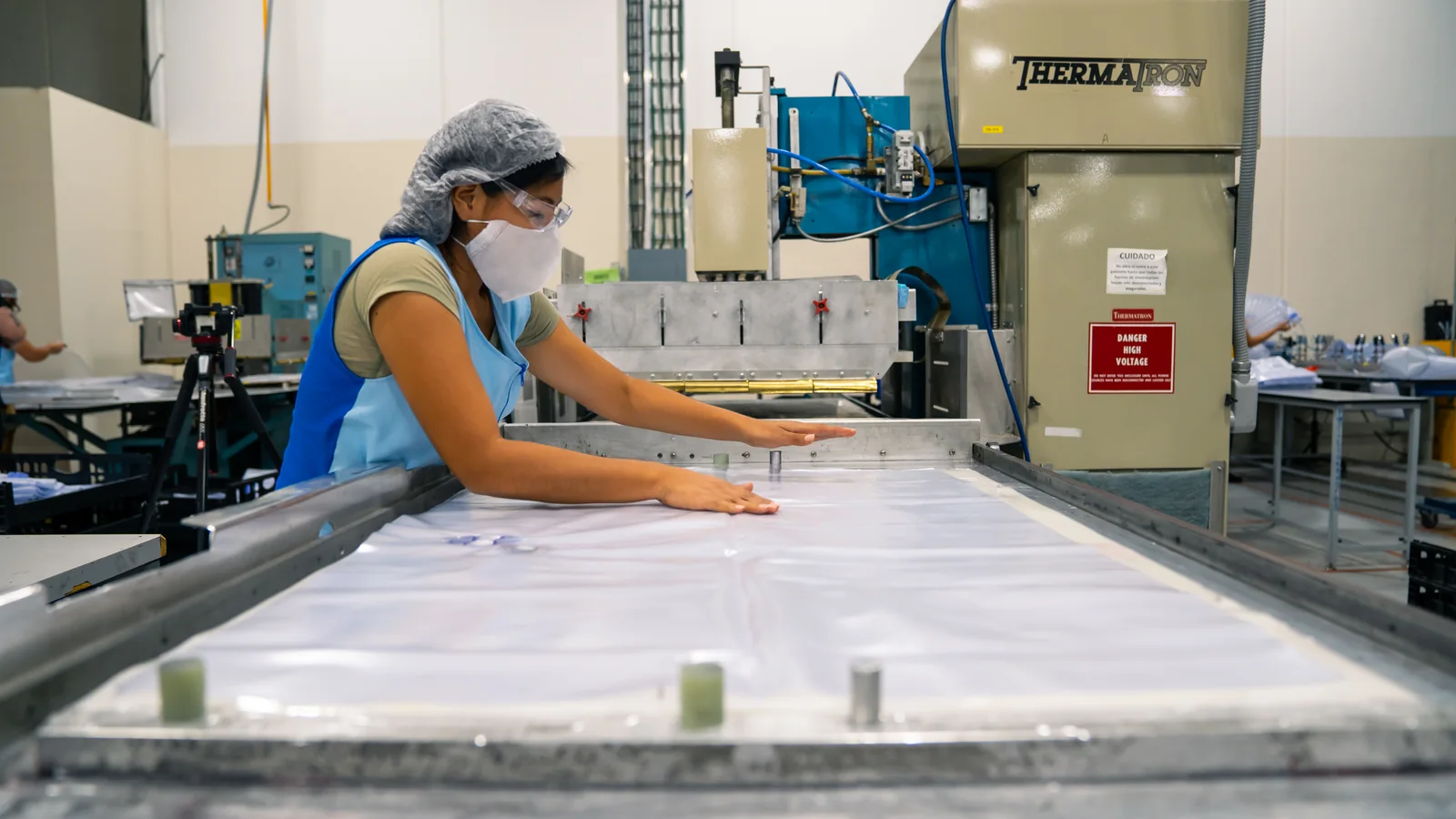 Cordica operator positioning flexible material at RF welding equipment